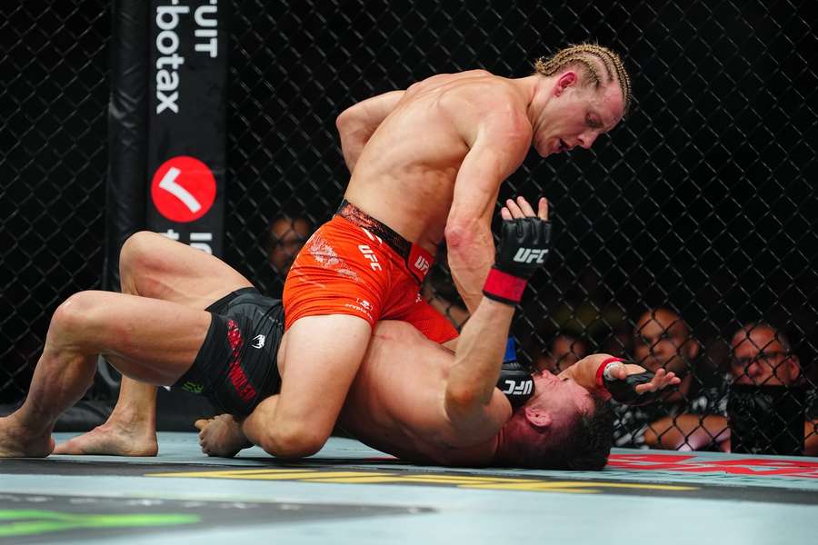 Paddy Pimblett aplicando finalização em cima do adversário no octógono do UFC